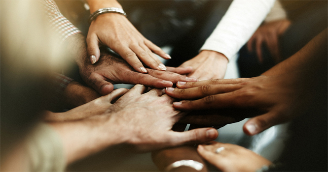 Closeup diverse people joining their hands