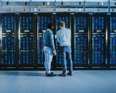 Two men standing in front of a data center