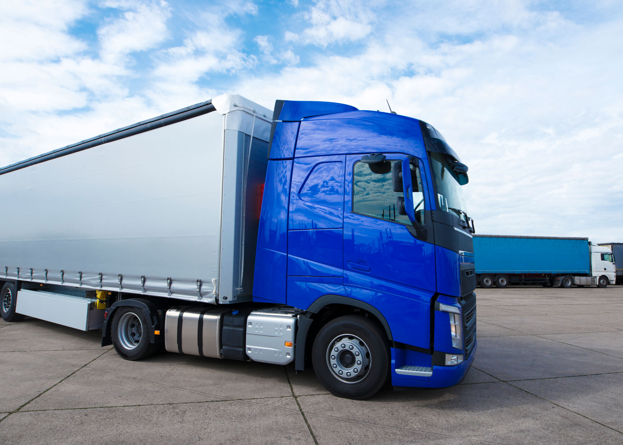 Blue tractor trailer delivery truck in a parking lot