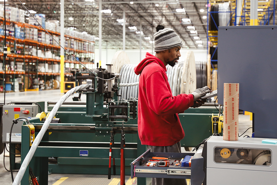 A warehouse worker cutting wire